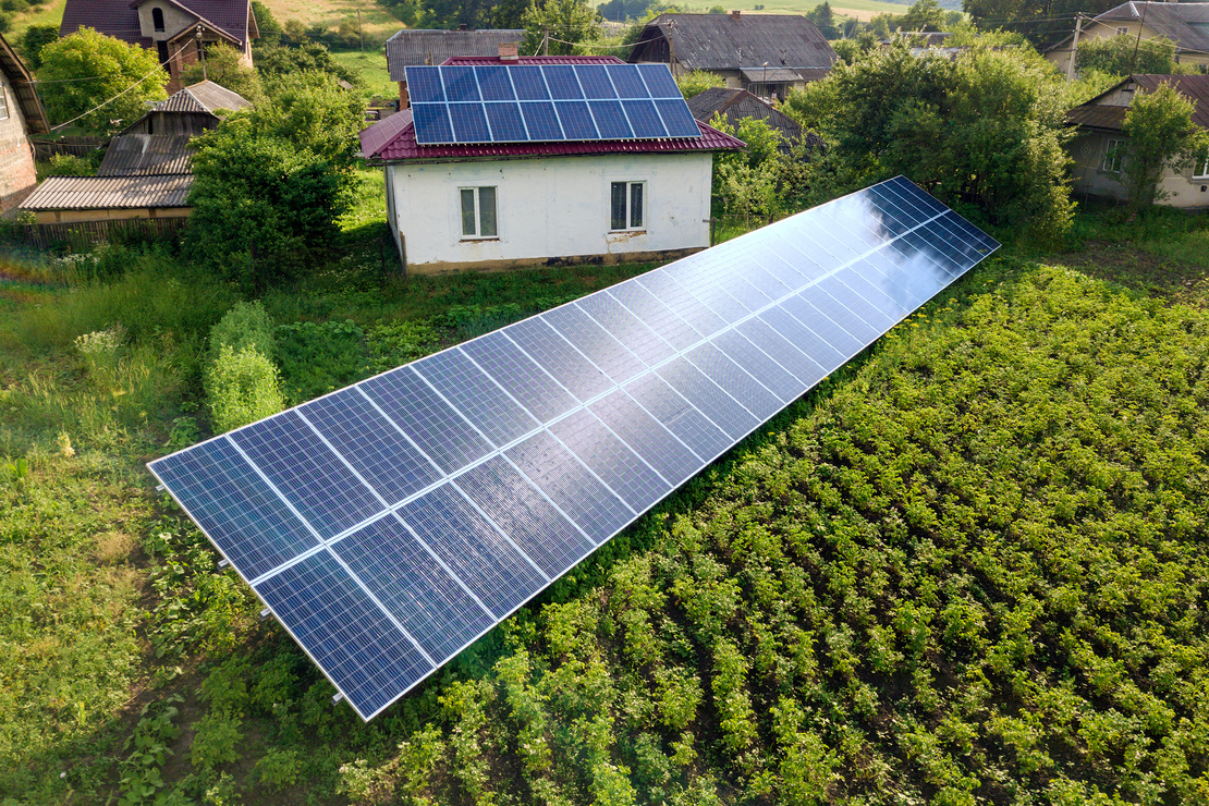 Aerial View of a House with Blue Solar Panels for Clean Energy.